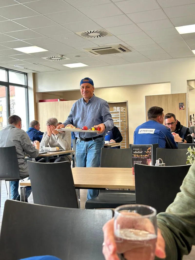 Günter mit einem Tablett in der Kantine, lächelnd