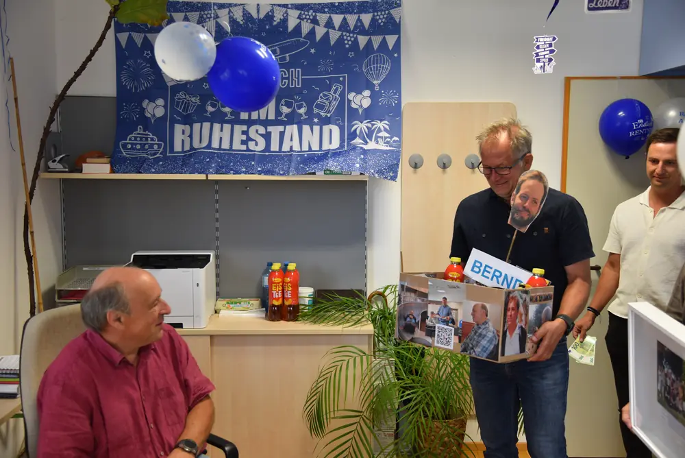 Die Übergabe der Geschenkkiste vor dem Ruhestand-Banner