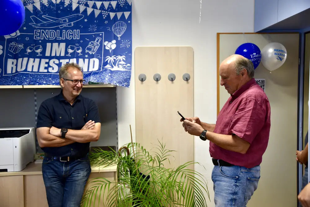 Günter fotografiert mit dem Handy, ein Kollege lacht dabei