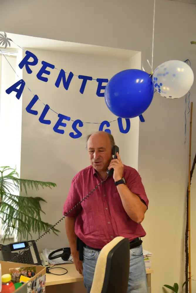 Günter telefoniert unter der „Rente gut, alles gut“-Girlande