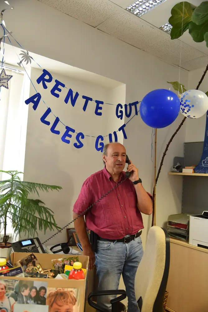 Günter am Telefon, Ballons und Girlande im Hintergrund